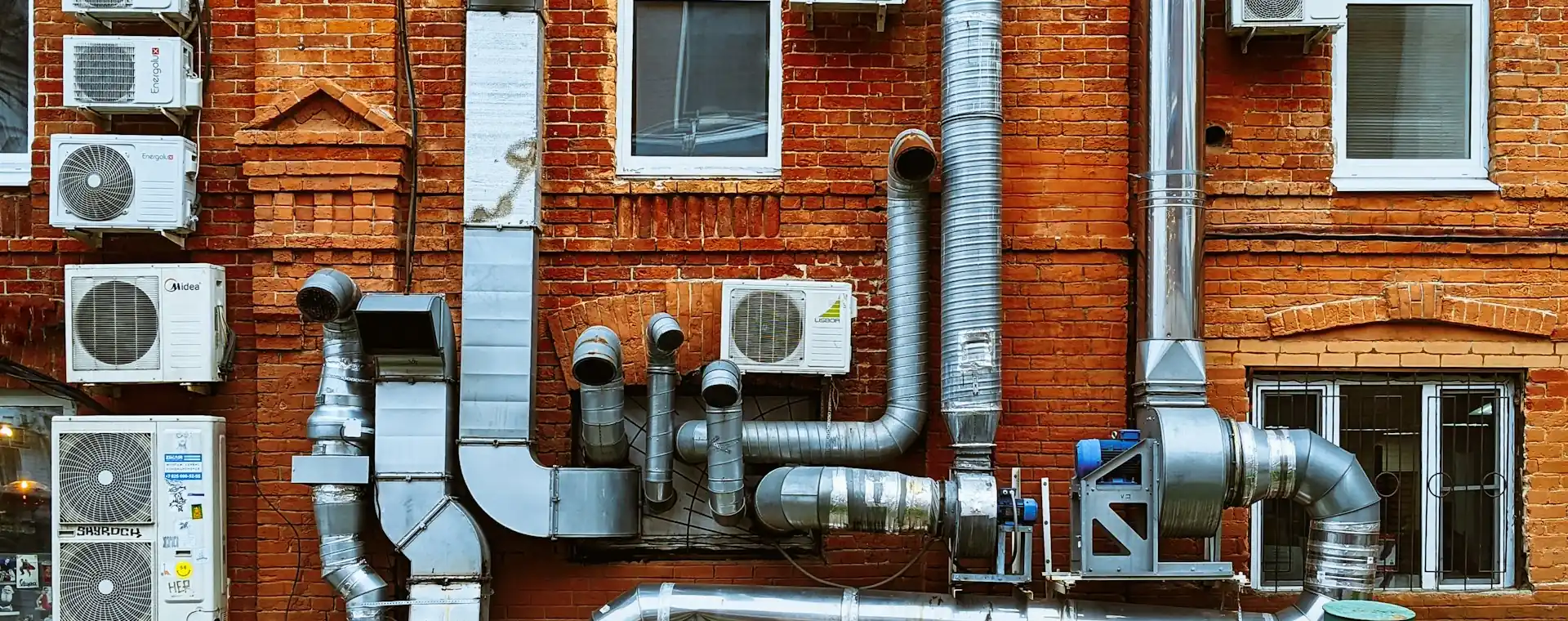 Building wall with AC units, ventilation ducts and an extraction fan