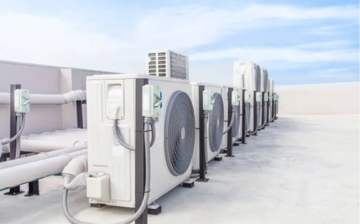 Row of outdoor AC condenser units on a commercial rooftop